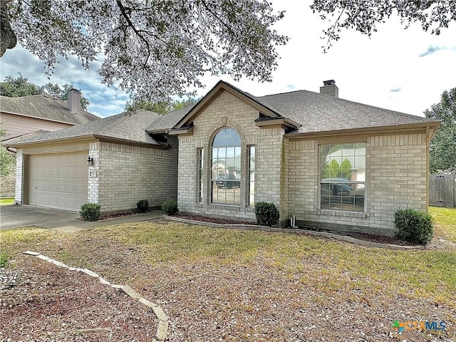 203 Canyon Crk, Victoria, TX 77901 - french country style house with brick siding, a garage, a chimney, and driveway