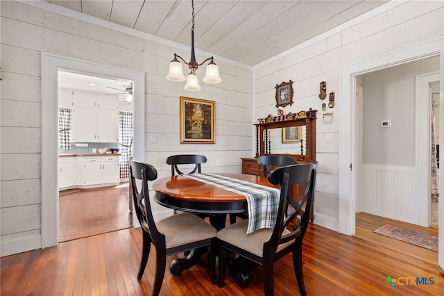 dining area featuring hardwood / wood-style flooring and ceiling fan with notable chandelier