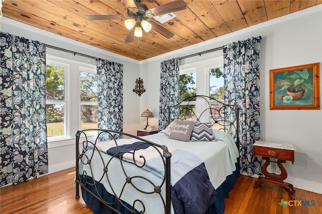 bedroom with multiple windows, wood-type flooring, ceiling fan, and wood ceiling