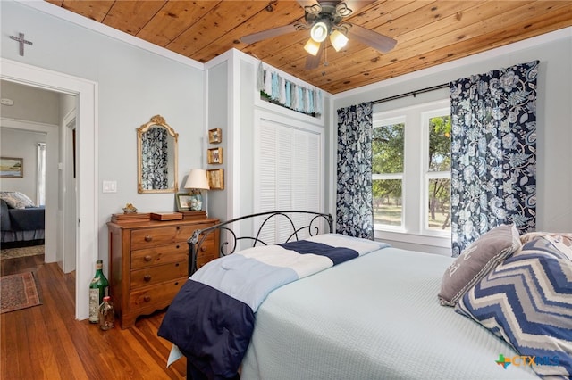 bedroom featuring hardwood / wood-style floors, ceiling fan, crown molding, and wooden ceiling