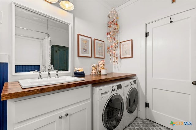 laundry area with sink, washer and dryer, and ornamental molding