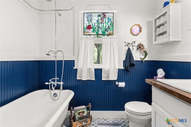 bathroom featuring tile patterned floors, vanity, toilet, and a bathtub