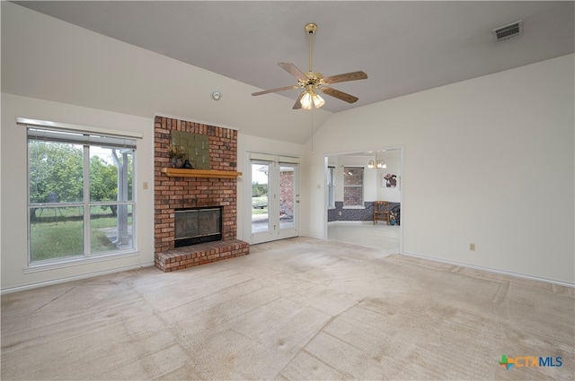 unfurnished living room with a brick fireplace, light colored carpet, ceiling fan, and vaulted ceiling