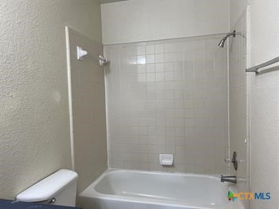 1200 Industrial Blvd, Killeen, TX 76549 - bathroom with toilet, shower / washtub combination, and a textured wall