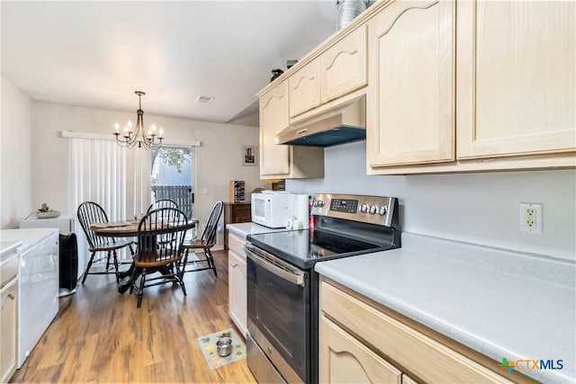 2039 Cornerstone Dr, New Braunfels, TX 78130 - kitchen with stainless steel electric range oven, white microwave, under cabinet range hood, wood finished floors, and a chandelier