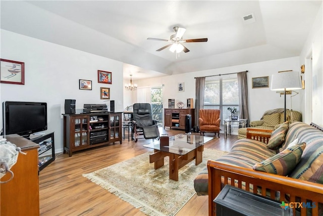 2039 Cornerstone Dr, New Braunfels, TX 78130 - living room with light wood finished floors, a tray ceiling, ceiling fan, and a chandelier