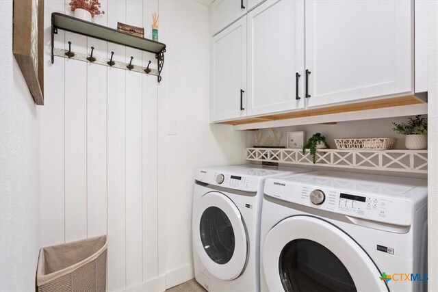 clothes washing area featuring cabinet space and independent washer and dryer