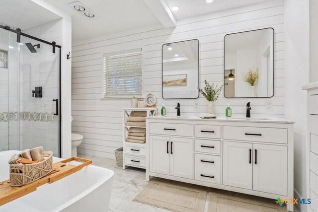 full bathroom with marble finish floor, a sink, a stall shower, and double vanity