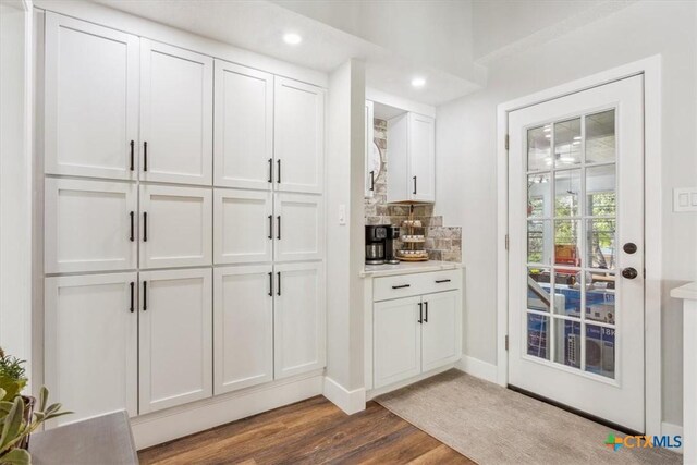 bar with bar area, tasteful backsplash, recessed lighting, baseboards, and wood finished floors
