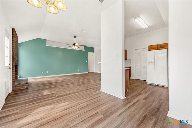 809 Filly Ln, Temple, TX 76504 - unfurnished living room featuring lofted ceiling, light wood-style flooring, ceiling fan, baseboards, and a chandelier