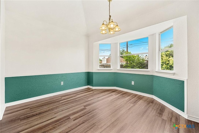 809 Filly Ln, Temple, TX 76504 - unfurnished room featuring a chandelier, baseboards, wood finished floors, a textured wall, and vaulted ceiling