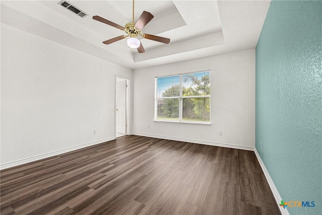 809 Filly Ln, Temple, TX 76504 - empty room with dark wood-style floors, baseboards, a textured wall, ceiling fan, and a raised ceiling