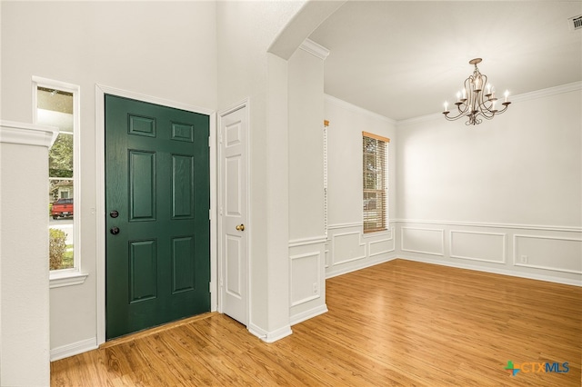 958 River Ter, New Braunfels, TX 78130 - foyer entrance featuring arched walkways, light wood-style flooring, a chandelier, crown molding, and a wainscoted wall