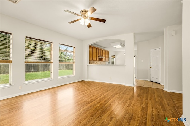 958 River Ter, New Braunfels, TX 78130 - unfurnished living room featuring light wood-style floors, ceiling fan, and arched walkways