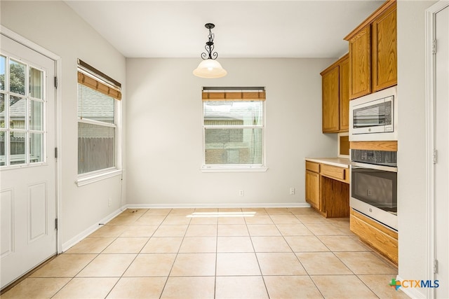 958 River Ter, New Braunfels, TX 78130 - kitchen with stainless steel appliances, brown cabinets, plenty of natural light, and decorative light fixtures