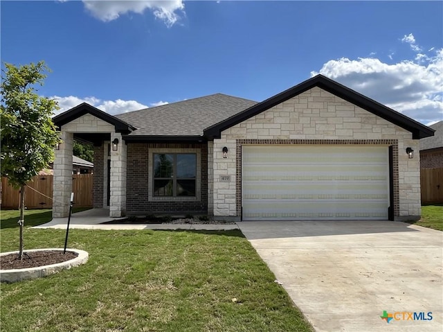 view of front of house featuring a garage, roof with shingles, a front yard, and fence