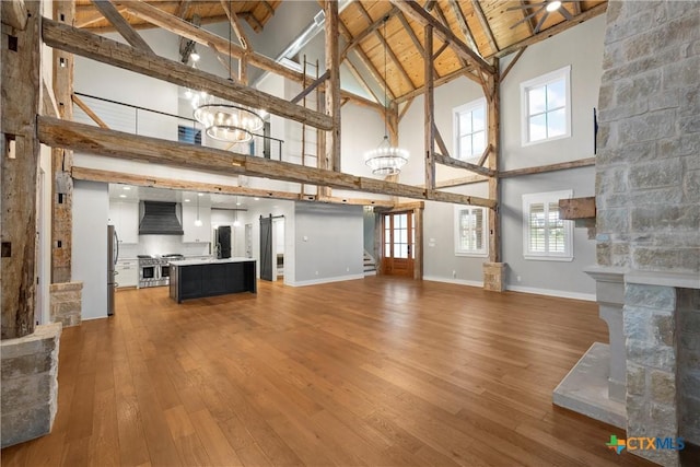 8300 Spicewood Springs Rd, China Spring, TX 76633 - unfurnished living room featuring high vaulted ceiling, a chandelier, light wood-style flooring, baseboards, and beamed ceiling