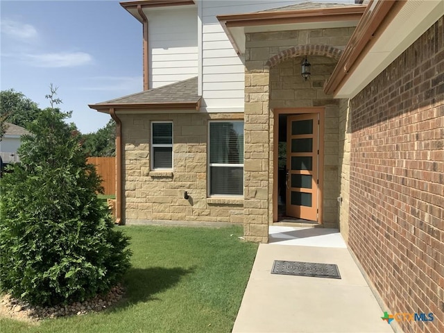 5818 Hamlet Dr, Belton, TX 76513 - view of exterior entry featuring roof with shingles, stone siding, and a yard