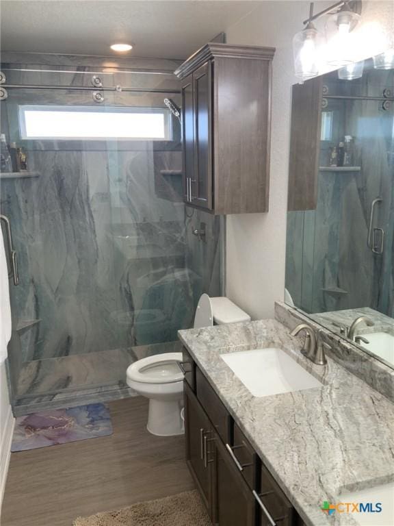 5818 Hamlet Dr, Belton, TX 76513 - bathroom featuring toilet, vanity, a marble finish shower, and wood finished floors