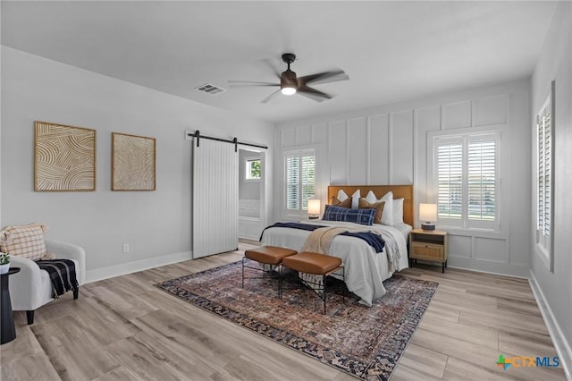 4430 Cedar Creek Rd, Temple, TX 76504 - bedroom with a barn door, light wood-style flooring, and a ceiling fan