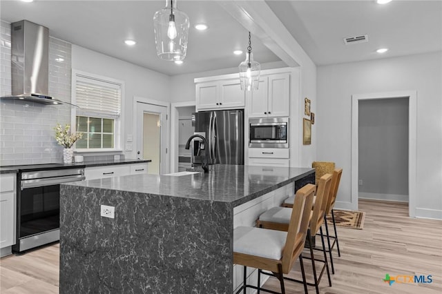 4430 Cedar Creek Rd, Temple, TX 76504 - kitchen featuring wall chimney exhaust hood, appliances with stainless steel finishes, tasteful backsplash, light wood finished floors, and recessed lighting
