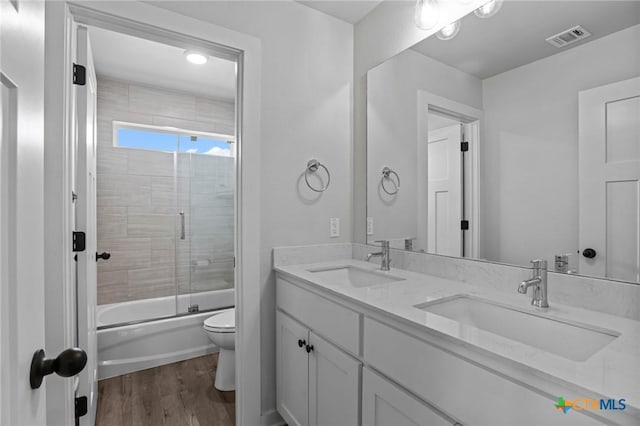 4430 Cedar Creek Rd, Temple, TX 76504 - full bathroom with double vanity, enclosed tub / shower combo, and wood finished floors