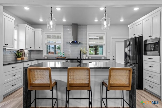 4430 Cedar Creek Rd, Temple, TX 76504 - kitchen with wall chimney range hood, stainless steel microwave, black fridge, decorative backsplash, and plenty of natural light
