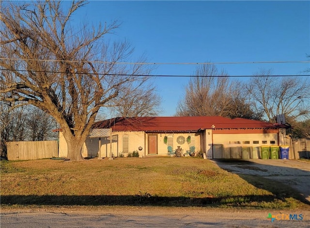 view of front of home featuring a garage, driveway, fence, and a front lawn