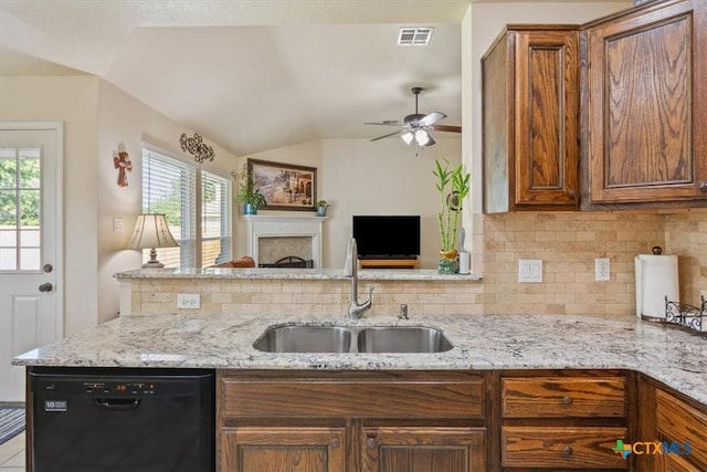 7204 Bluegrass Ct, Temple, TX 76502 - kitchen with black dishwasher, a sink, brown cabinetry, tasteful backsplash, and vaulted ceiling
