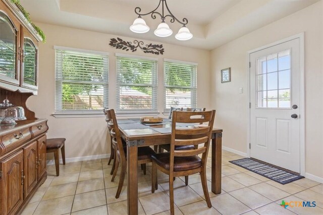 7204 Bluegrass Ct, Temple, TX 76502 - dining area with light tile patterned floors, baseboards, a raised ceiling, and a chandelier