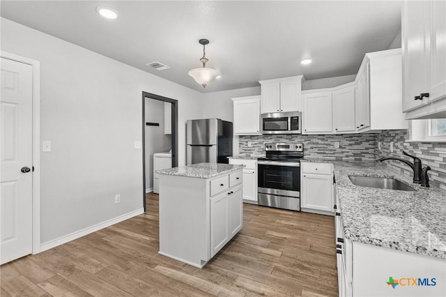2550 Belle Hubbard Trl, Belton, TX 76513 - kitchen featuring appliances with stainless steel finishes, decorative backsplash, white cabinetry, light wood finished floors, and recessed lighting