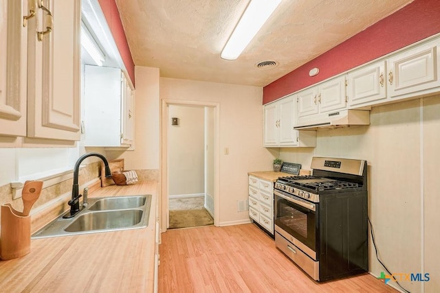 1905 S 53rd St, Temple, TX 76504 - kitchen with stainless steel range with gas cooktop, a sink, under cabinet range hood, light wood finished floors, and light countertops