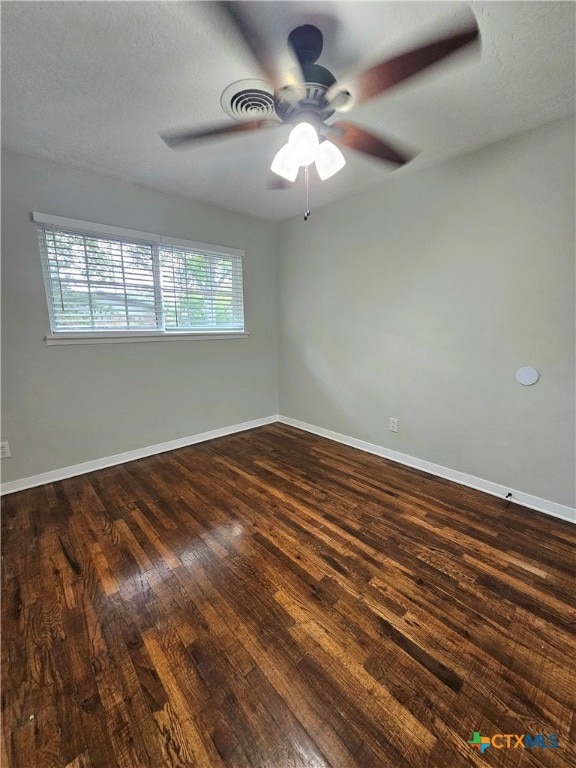 spare room with ceiling fan, a textured ceiling, and dark hardwood / wood-style floors