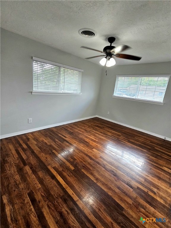 empty room with dark wood-type flooring, ceiling fan, and a textured ceiling