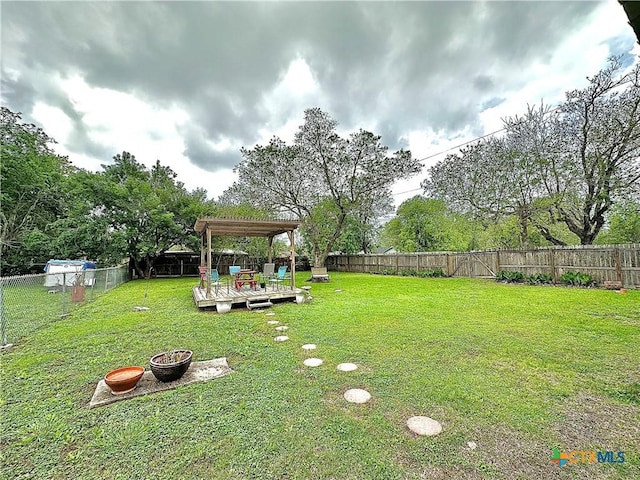 view of yard with a deck, a fenced backyard, and a pergola