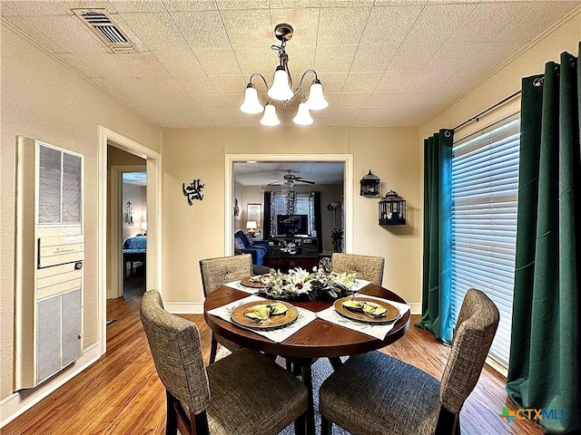 dining space featuring a chandelier, light wood-type flooring, and visible vents