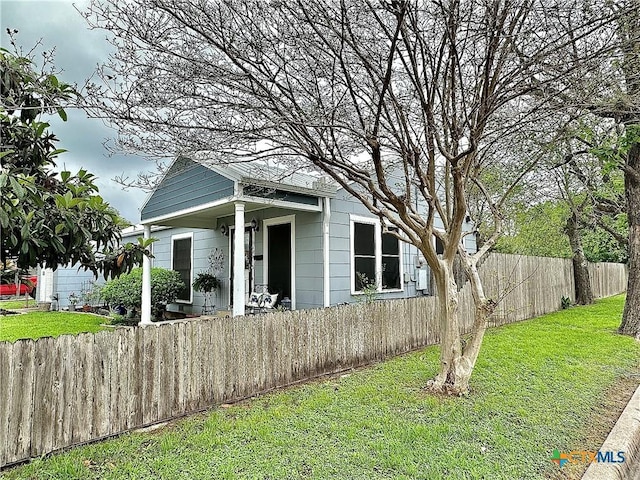 view of front facade with a front lawn and fence