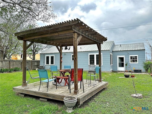 wooden terrace with outdoor dining space, a lawn, fence, and a pergola