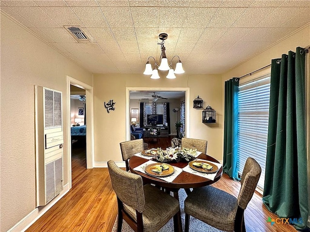 dining room featuring a notable chandelier, baseboards, visible vents, and light wood-style floors