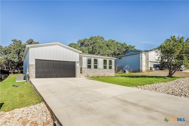 single story home featuring a garage and a front lawn