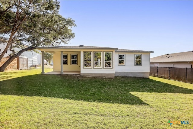 rear view of property featuring a yard and a patio area