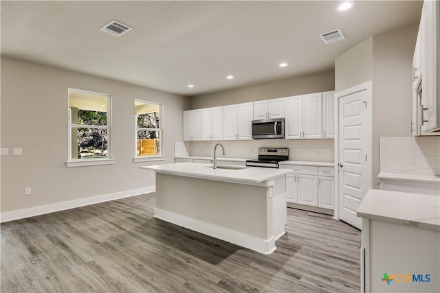 kitchen featuring sink, a kitchen island with sink, stainless steel appliances, wood-type flooring, and white cabinets