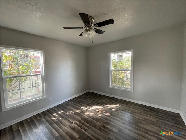 spare room featuring dark hardwood / wood-style floors, ceiling fan, and a textured ceiling