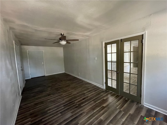 empty room with a textured ceiling, ceiling fan, dark wood-type flooring, and french doors