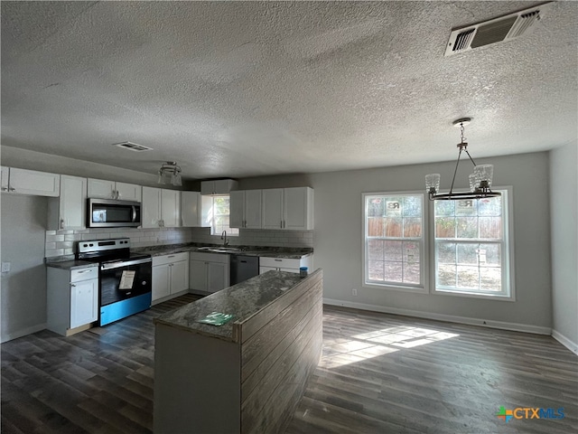 kitchen with white cabinets, pendant lighting, dark wood-type flooring, and appliances with stainless steel finishes