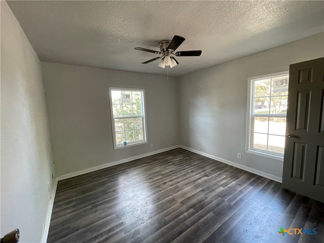 unfurnished room featuring dark hardwood / wood-style flooring, a healthy amount of sunlight, and a textured ceiling