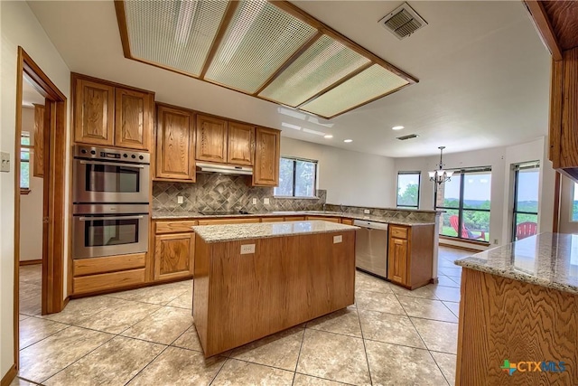 2721 Barton Hill Dr, Bulverde, TX 78163 - kitchen with stainless steel appliances, a peninsula, under cabinet range hood, a kitchen island, and backsplash