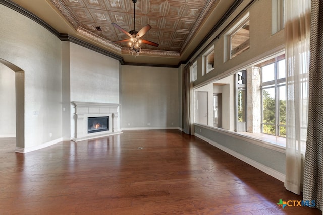 unfurnished living room with dark wood-type flooring, ceiling fan, and crown molding