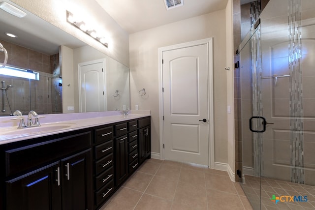 bathroom with vanity, a shower with door, and tile patterned flooring