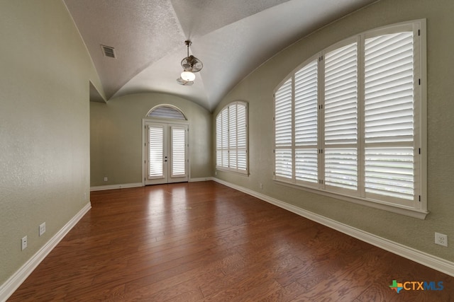 interior space with french doors, dark hardwood / wood-style flooring, lofted ceiling, and a textured ceiling